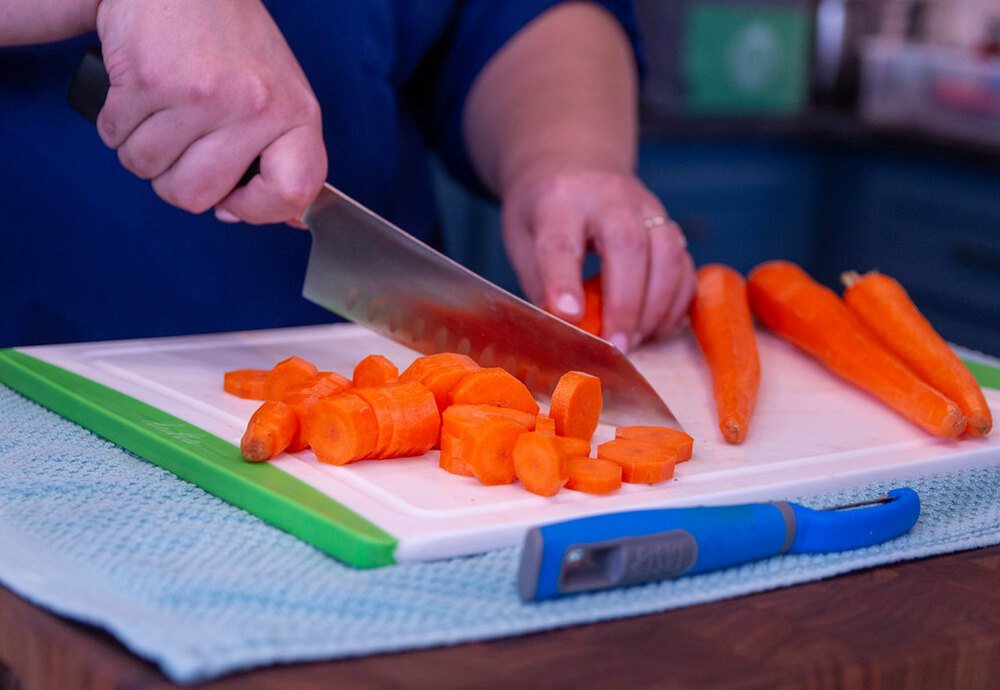 Dicing carrots with a chef knife on a cutting board